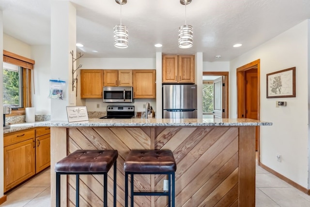 175 Argentine Ct Unit 1513, Keystone, CO 80435 - kitchen featuring appliances with stainless steel finishes, light tile patterned floors, light stone countertops, decorative light fixtures, and a breakfast bar
