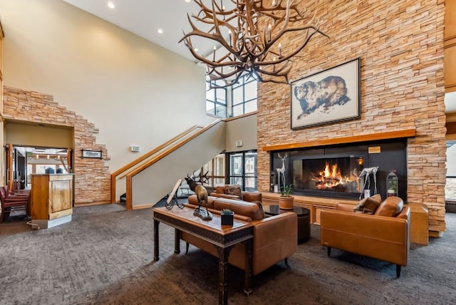 175 Argentine Ct Unit 1513, Keystone, CO 80435 - living room featuring carpet flooring, a chandelier, a towering ceiling, stairs, and a stone fireplace