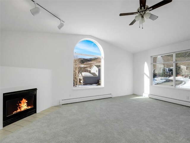 662 Alpine Rd, Dillon, CO 80435 - unfurnished living room with baseboard heating, track lighting, lofted ceiling, carpet, and a fireplace with flush hearth