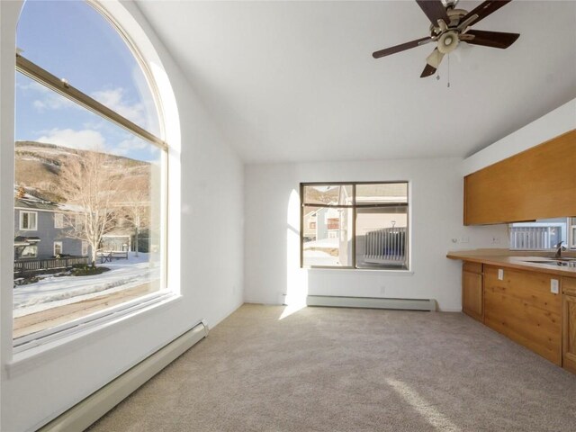 662 Alpine Rd, Dillon, CO 80435 - unfurnished living room with baseboard heating, light colored carpet, vaulted ceiling, ceiling fan, and a sink
