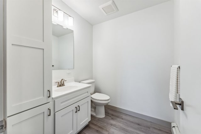0630 Temple Trl, Frisco, CO 80443 - half bathroom with wood finished floors, a baseboard heating unit, vanity, toilet, and visible vents