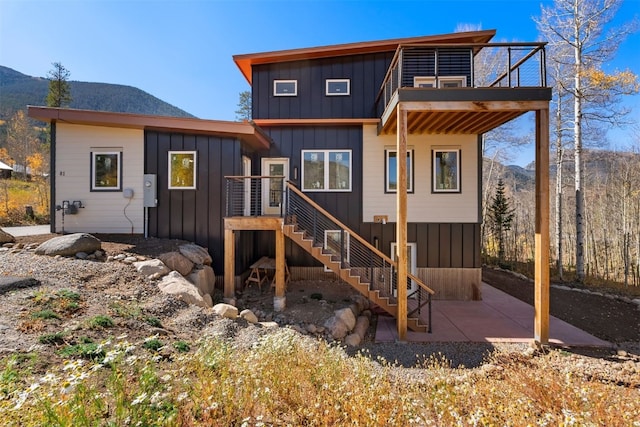 0630 Temple Trl, Frisco, CO 80443 - rear view of house with board and batten siding, a deck with mountain view, and a patio