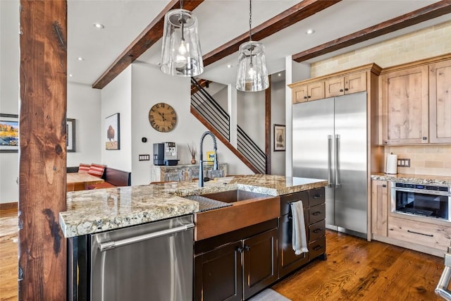 2357 Poma Ln Lot 2, Steamboat Springs, CO 80487 - kitchen featuring stainless steel appliances, a sink, dark wood-style floors, beamed ceiling, and light stone counters