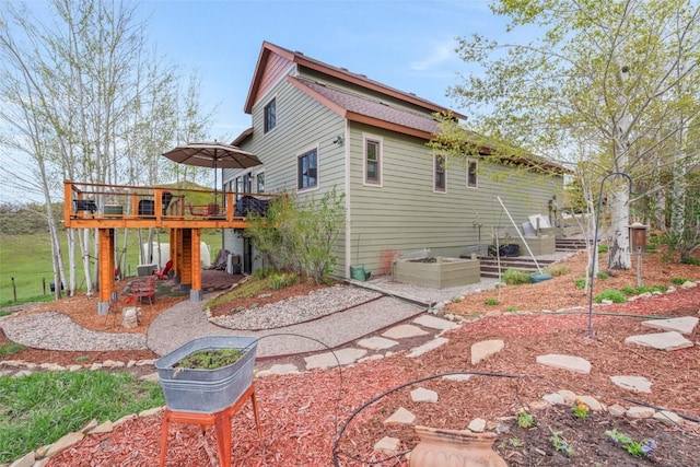 29780 Riffle Run, Oak Creek, CO 80467 - back of property featuring a deck, a patio, and a garden