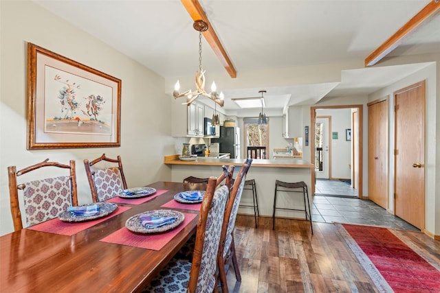 dining space featuring wood finished floors, baseboards, and a notable chandelier