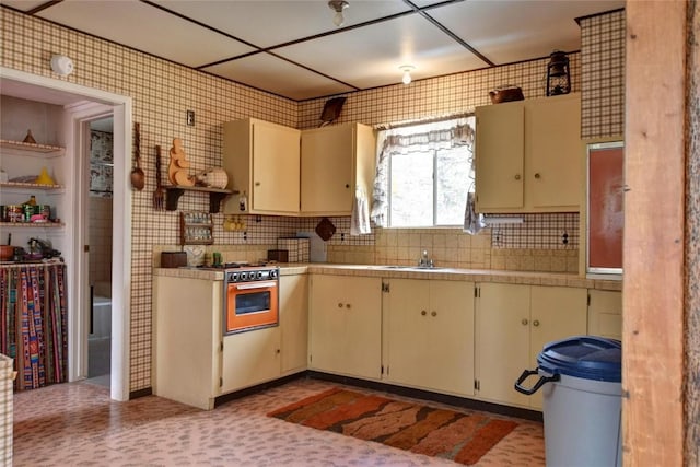 490 Teller St, Lake George, CO 80827 - kitchen with cream cabinets, oven, backsplash, and stainless steel range with gas cooktop