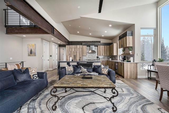 living area featuring high vaulted ceiling and light wood-style flooring
