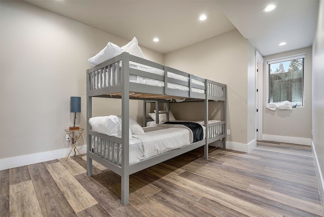 bedroom featuring baseboards, recessed lighting, and wood finished floors