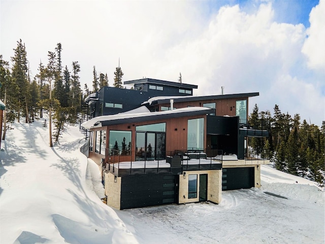 snow covered house featuring a garage