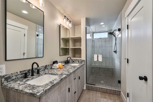 full bathroom with double vanity, a sink, and a stall shower