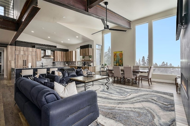 living area featuring recessed lighting, a ceiling fan, vaulted ceiling with beams, and wood finished floors