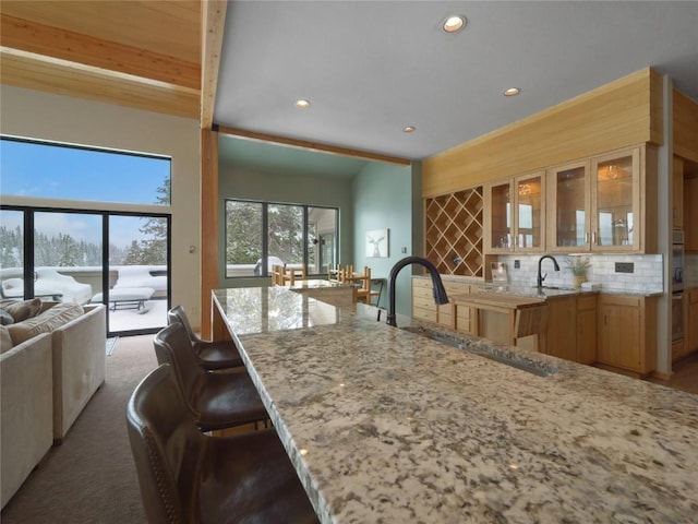 203 Gentian Rd, Keystone, CO 80435 - kitchen with a sink, light stone counters, recessed lighting, open floor plan, and decorative backsplash