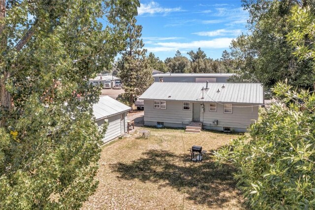 149 N 2nd St, Hayden, CO 81639 - rear view of house featuring a yard, an outbuilding, and metal roof