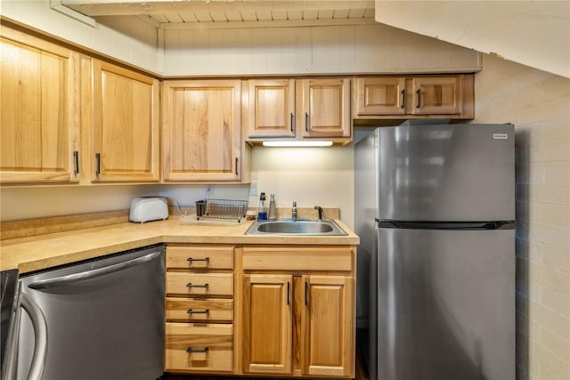 kitchen featuring appliances with stainless steel finishes, a sink, and light countertops