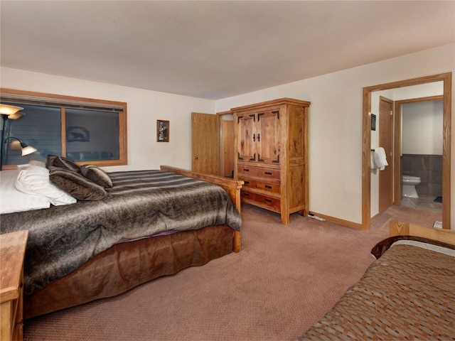 carpeted bedroom featuring connected bathroom and baseboards