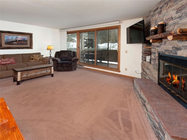 living area with baseboard heating, a stone fireplace, and carpet flooring