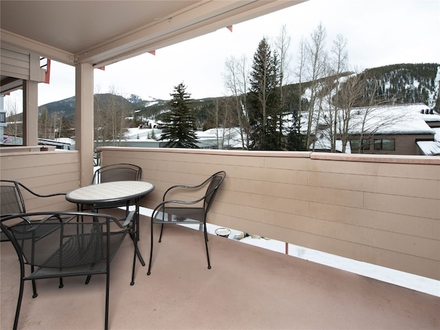 snow covered back of property with a mountain view