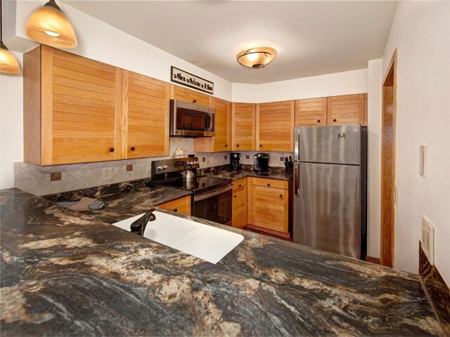 22804 US Highway 6 Unit 102, Keystone, CO 80435 - kitchen featuring appliances with stainless steel finishes, tasteful backsplash, and dark stone countertops