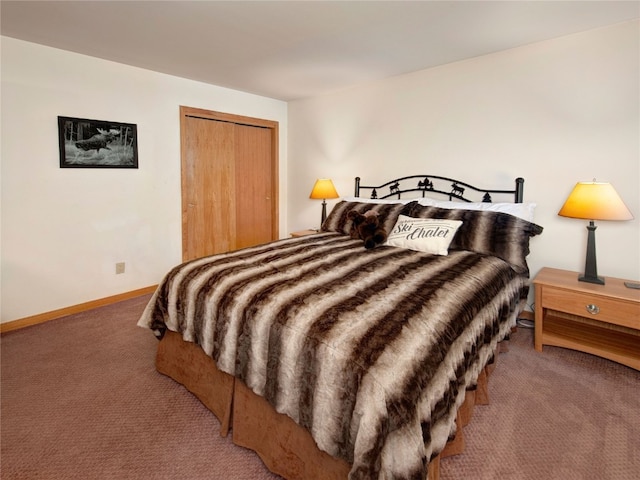 carpeted bedroom featuring a closet and baseboards