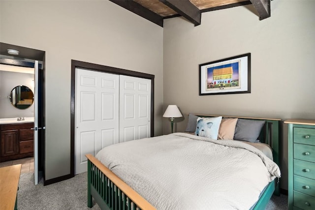 2583 Apres Ski Way Unit 4, Steamboat Springs, CO 80487 - bedroom featuring light colored carpet, beam ceiling, a sink, a closet, and ensuite bathroom