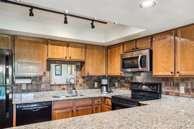 4612 Ryan Gulch Rd Unit 4612, Silverthorne, CO 80498 - kitchen with black appliances, decorative backsplash, brown cabinetry, light stone counters, and rail lighting