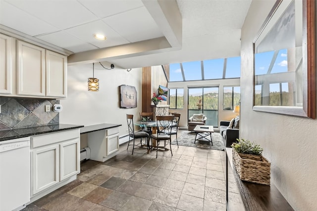 631 Village Rd Unit 34330, Breckenridge, CO 80424 - kitchen with white dishwasher, baseboard heating, backsplash, dark countertops, and stone tile floors