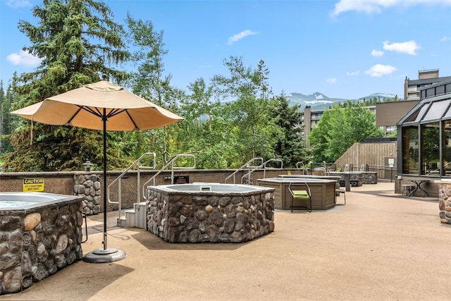 631 Village Rd Unit 34330, Breckenridge, CO 80424 - view of patio with an outdoor fire pit, a hot tub, and a mountain view
