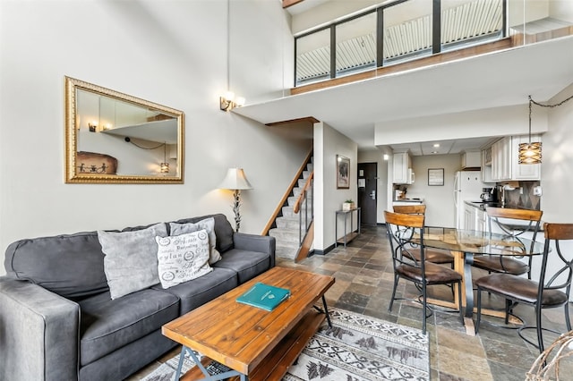 631 Village Rd Unit 34330, Breckenridge, CO 80424 - living area with stone tile floors, stairway, and a towering ceiling