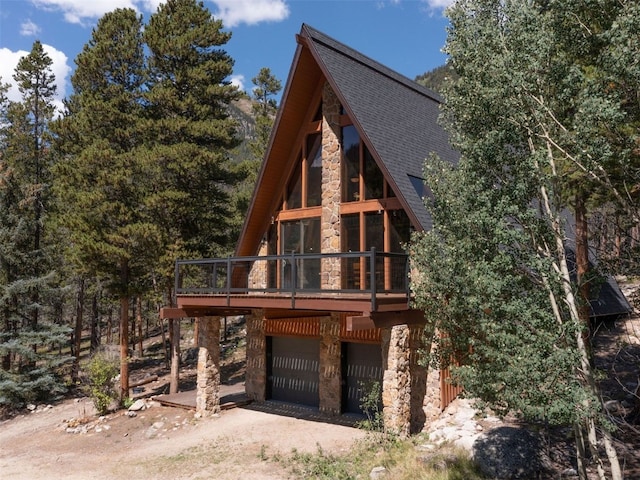 12715 E State Highway 82, Twin Lakes, CO 81251 - a-frame home with stone siding, a shingled roof, a garage, and a wooden deck
