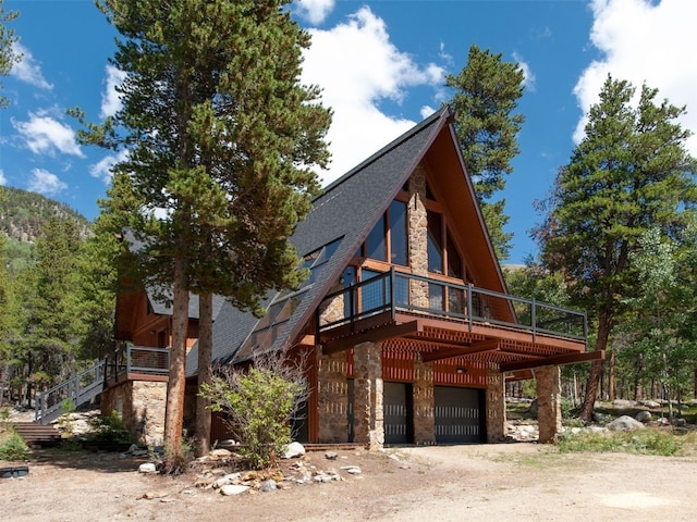 12715 E State Highway 82, Twin Lakes, CO 81251 - view of front of house with stone siding, a garage, dirt driveway, and a deck