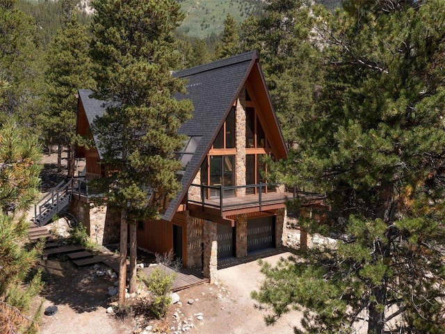12715 E State Highway 82, Twin Lakes, CO 81251 - a-frame style home featuring stone siding, a garage, a view of trees, and a shingled roof