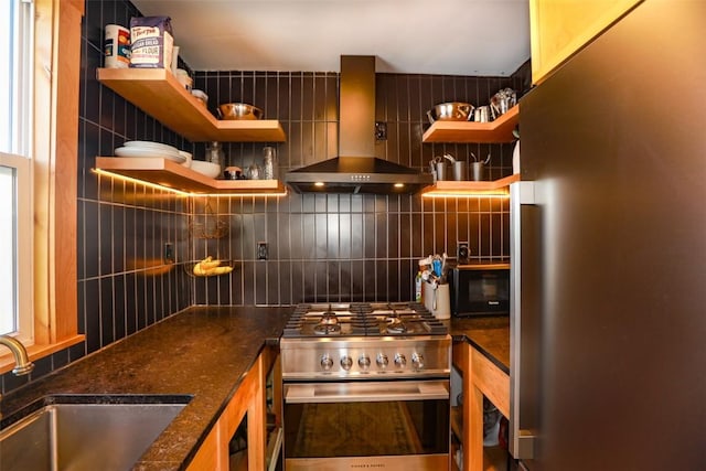 interior space featuring open shelves, backsplash, appliances with stainless steel finishes, and wall chimney range hood