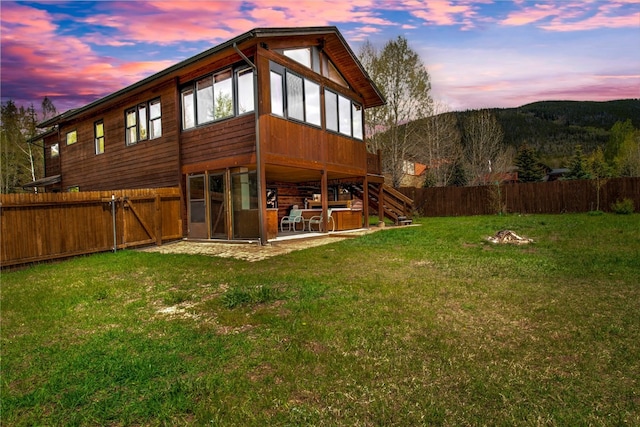 196 Vail Cir, Dillon, CO 80435 - back of house at dusk featuring a patio area, a fenced backyard, and stairway