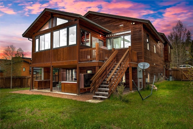 196 Vail Cir, Dillon, CO 80435 - back of property at dusk featuring a hot tub, a fenced backyard, a patio, and a wooden deck