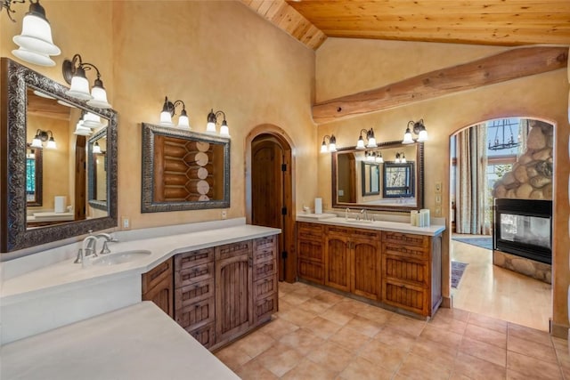 27800 Wapiti Way, Steamboat Springs, CO 80487 - bathroom with wood ceiling, vaulted ceiling, a stone fireplace, vanity, and tile patterned flooring
