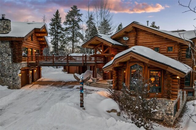 27800 Wapiti Way, Steamboat Springs, CO 80487 - view of front of house with log exterior, a chimney, and a wooden deck