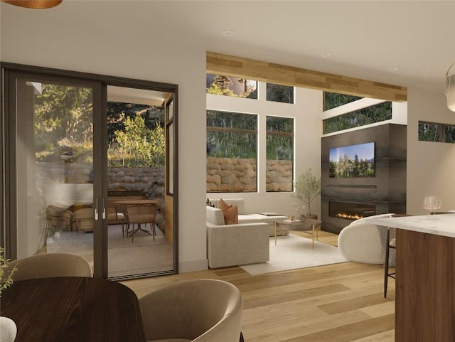 entryway with a glass covered fireplace and light wood-style flooring