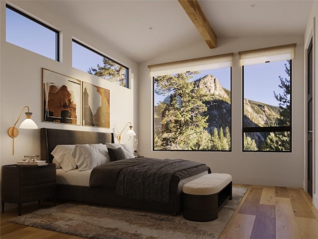 bedroom featuring lofted ceiling with beams and wood finished floors