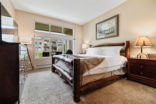 bedroom with a baseboard heating unit, carpet flooring, and baseboards