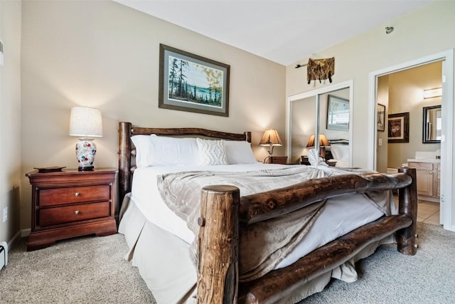 bedroom featuring light carpet and ensuite bathroom
