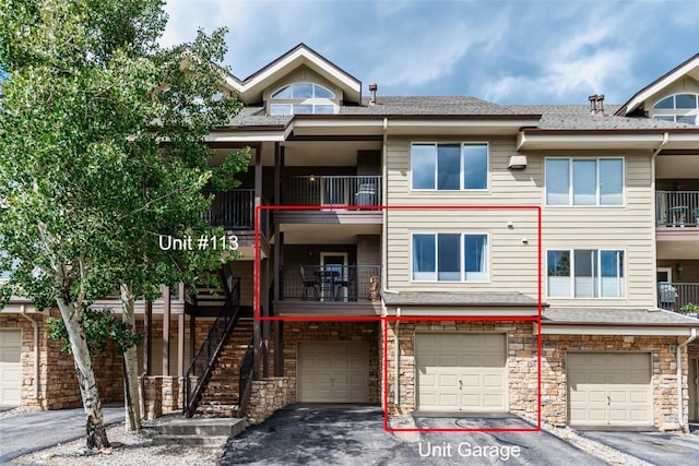 view of property with driveway, stairs, and a garage