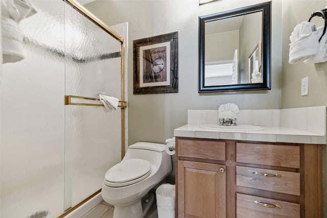 bathroom with a shower stall, toilet, vanity, and tile patterned flooring