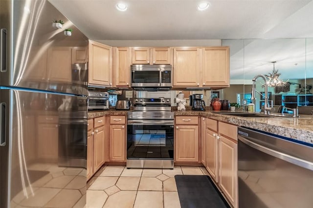 kitchen featuring recessed lighting, appliances with stainless steel finishes, light brown cabinets, and a sink