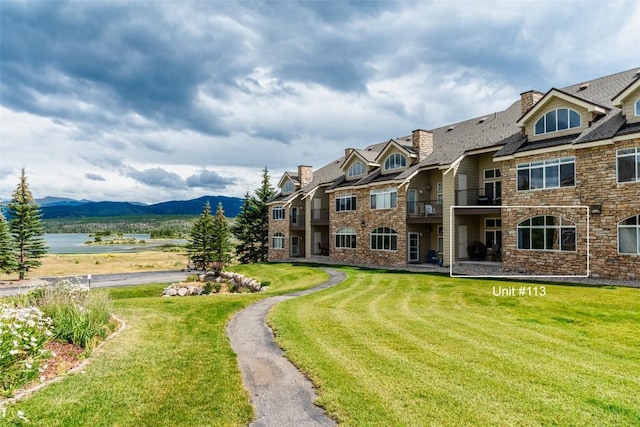 view of property's community with a lawn and a mountain view