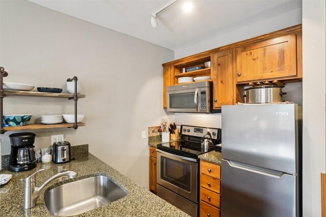 129 River Run Rd Unit 8055, Keystone, CO 80435 - kitchen with appliances with stainless steel finishes, open shelves, a sink, brown cabinets, and stone counters