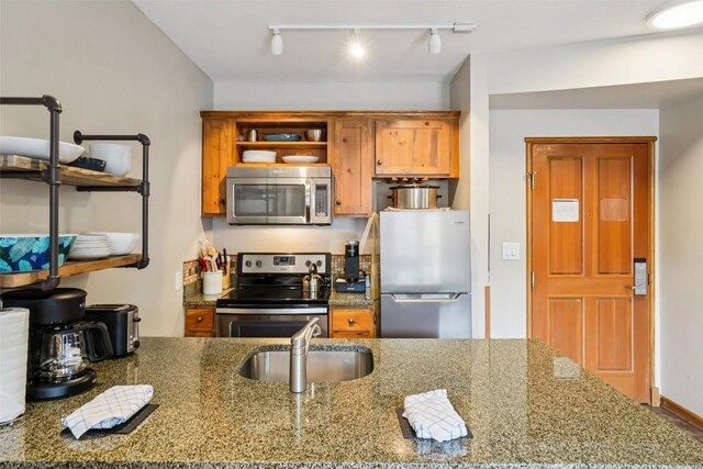129 River Run Rd Unit 8055, Keystone, CO 80435 - kitchen with stainless steel appliances, a sink, track lighting, open shelves, and stone counters