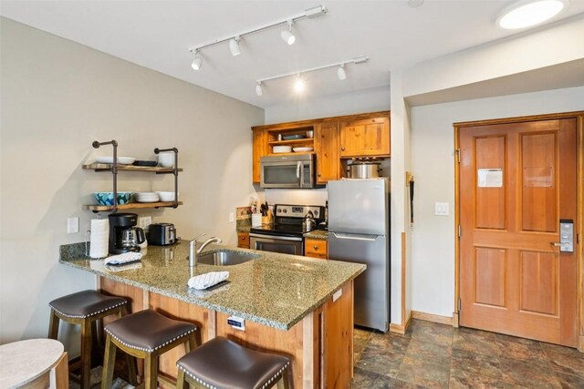 129 River Run Rd Unit 8055, Keystone, CO 80435 - kitchen with appliances with stainless steel finishes, open shelves, a sink, and a peninsula