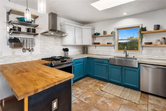 651 Lamb Mountain Rd, Fairplay, CO 80440 - kitchen with open shelves, wall chimney exhaust hood, appliances with stainless steel finishes, blue cabinets, and a skylight