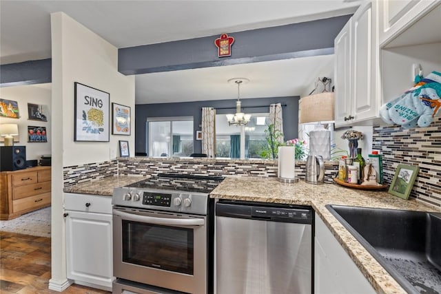 133 Woodchuck Ct, Silverthorne, CO 80498 - kitchen with stainless steel appliances, a chandelier, white cabinets, and backsplash