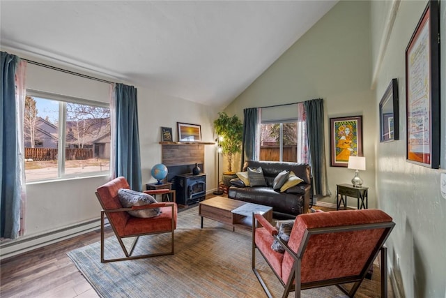 133 Woodchuck Ct, Silverthorne, CO 80498 - living room with a baseboard heating unit, a wood stove, wood finished floors, high vaulted ceiling, and baseboards
